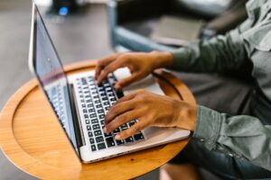 A Person's Hands Typing on a Laptop Using Rental Property Accounting Software