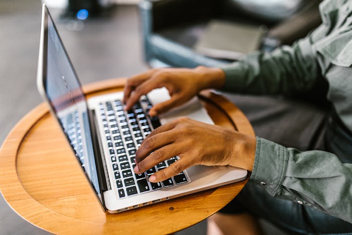 A Person's Hands Typing on a Laptop Using Rental Property Accounting Software